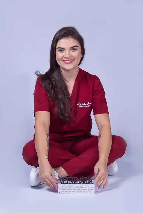 Dra. Kathy Alves sentada no chão, de uniforme
