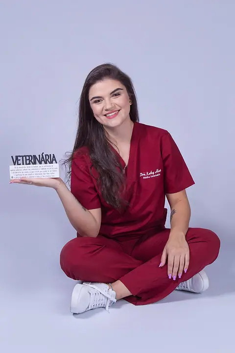 Dra. Kathy Alves segurando uma placa escrita Veterinária